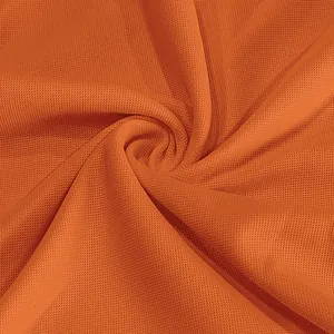 Macro view of breathable orange quick-dry mesh fabric texture for Polo shirts