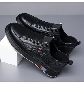 Λεπτομέρεια μαύρων δερμάτινων sneaker με σχέδιο κροκόδειλου και τρίχρωμες ρίγες