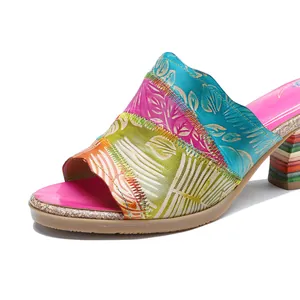 Primo piano di sandali con tacco in pelle patchwork vintage fatti a mano con motivo a foglie.