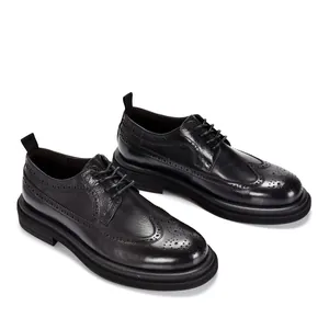 Macro view of black leather brogue shoes featuring vintage wingtip carving details