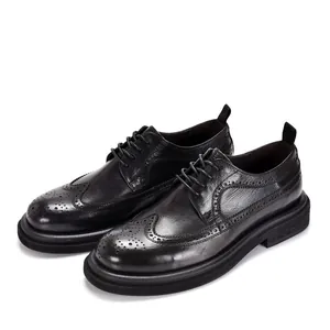 Professional detail shot of black leather brogue shoes with classic wingtip carving details.