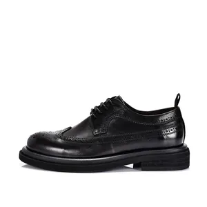 Side profile detail of black leather brogue shoes with elegant wingtip carving.