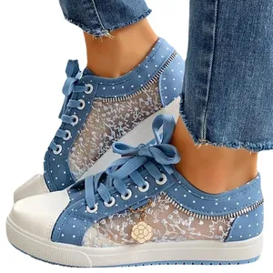 Modische blaue Polka-Dot-Sneaker mit weißem Blumen-Spitzengewebe und einem Goldanhänger