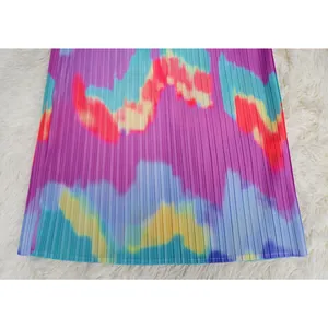 Primer plano de tela plisada tie-dye vibrante para un vestido de verano con mangas murciélago