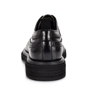 Detailed view of the heel and brogue patterns on black leather men's formal shoes