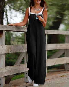 Outdoor lifestyle shot of a woman in a black ice silk wide-leg jumpsuit with thin straps.