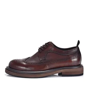 Side detail of vintage brown leather brogue shoes with classic wingtip carving for men