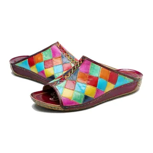 Dettaglio di ciabatte in pelle colorate con cuciture fatte a mano e motivi patchwork