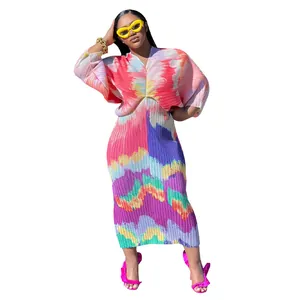 Detalle de vestido largo plisado de colores intensos con mangas de murciélago y escote