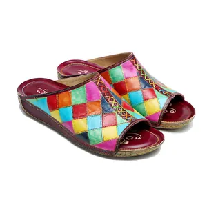 Dettaglio di ciabatte piatte in pelle colorata con motivo patchwork vintage