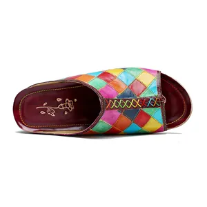 Dettaglio di ciabatte in pelle a scacchi colorati con design patchwork vintage strofinato.