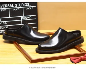 Detail showing the premium shiny black finish of men's leather mules with thick soles.