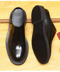 Detailed view of glossy black leather backless loafers with thick anti-slip sole