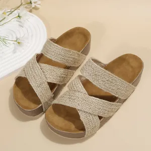 Detailed view of women's flatform slide sandals with criss-cross straw woven straps