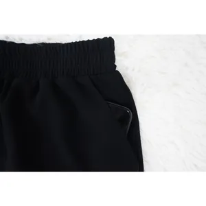 Detalle de cintura elástica y bolsillo lateral en pantalones cortos de playa de gasa negra