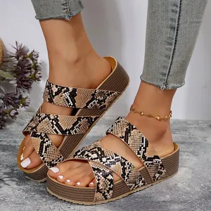 Close-up of women's snakeskin platform sandals with crossover straps and thick sole