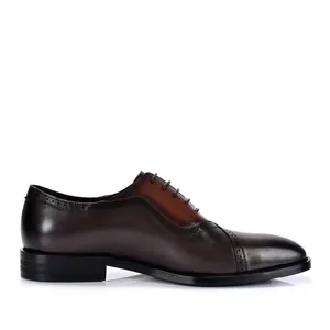 Vista de perfil de zapatos Oxford de cuero para hombre con detalles clásicos de brogue.