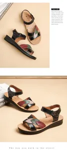 Macro view of black leather sandals featuring colorful leaf patterns and a soft sole.