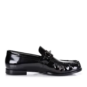 Vista lateral detallada de elegantes mocasines de charol negro con bocado metálico