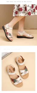 Detailed view of cream leather mother sandals with colorful leaf design on wedge sole.