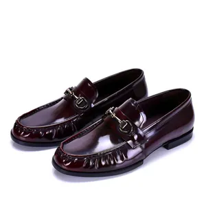 Vista detallada de mocasines para hombre de charol burdeos brillante con hebilla de bocado.