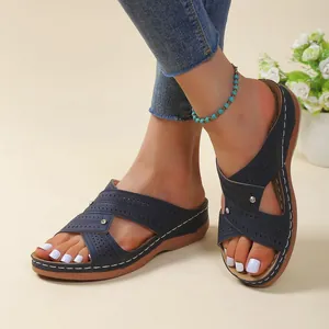 Close-up view of dark blue wedge platform sandals with hollow design and stitching