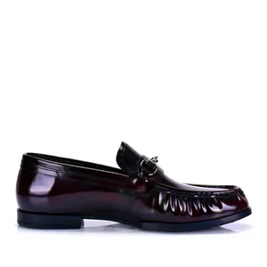 Vista lateral dettagliata de un elegante mocasín de charol burdeos para hombre de moda