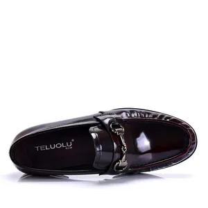 Primer plano de mocasines para hombre en charol burdeos con detalle de hebilla.