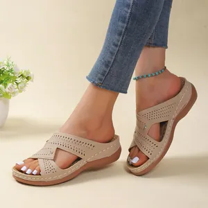 Close-up detail of women's comfortable beige wedge sandals with perforated design