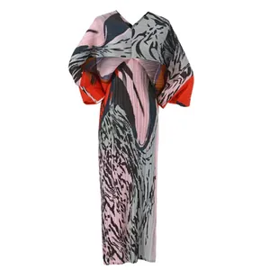 Primer plano de vestido largo plisado con estampado abstracto y mangas murciélago