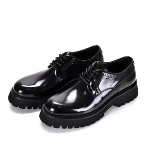 Detail van zwarte laklederen heren brogues met een dikke rubberen profielzool en plateau