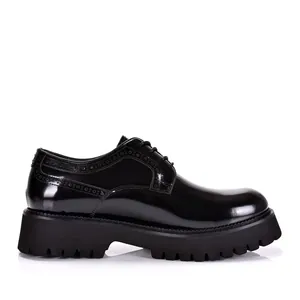 Gedetailleerd zijaanzicht van zwarte lakschoenen voor heren met brogue-details platform