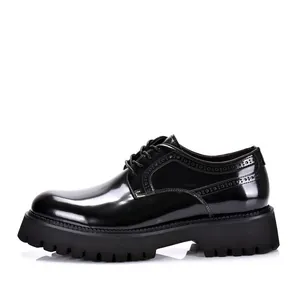 Zijaanzicht detail van zwarte lakleren herenschoenen met dikke zool en brogue details