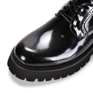 Detail van zwarte lakschoen voor heren met brogue-details en een grove profielzool
