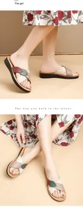 Detail view of women's genuine leather flat sandals with decorative leaf straps.