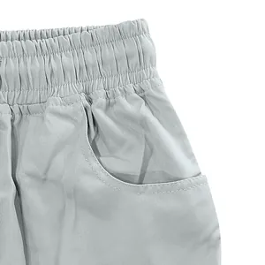 Dettaglio dell'elastico in vita e della tasca dei pantaloncini cargo grigi da uomo