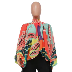 Dettaglio ravvicinato di una blusa in chiffon con stampa vivace e maniche a pipistrello