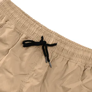 Dettaglio della vita elastica e della coulisse nera sui pantaloncini cargo kaki