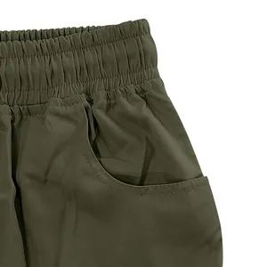 Vista dettagliata della vita elastica e della tasca sui pantaloncini cargo uomo verde oliva.
