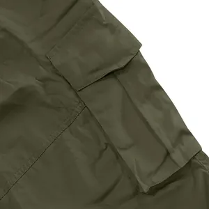 Vista macro dettagliata della tasca cargo verde oliva sui pantaloncini estivi tattici da uomo