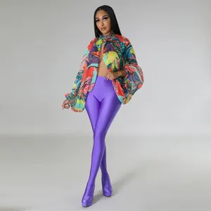 Dettaglio di una vivace camicetta in chiffon a fiori con eleganti maniche a pipistrello.