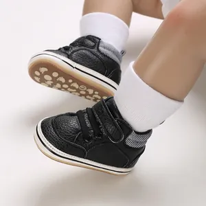 Close-up of black infant high-top walking shoes with soft white soles and grip pattern.