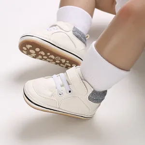 Detail view of cream white soft sole baby walking shoes with velcro strap.