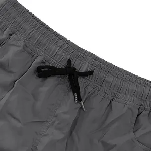 Vista macro dettagliata dei pantaloncini cargo grigi da uomo con elastico e coulisse nera.