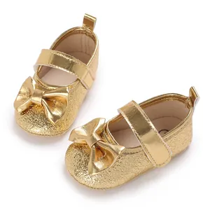 Detailansicht goldener Baby-Prinzessinnenschuhe für Mädchen mit einer Schleife auf Weiß
