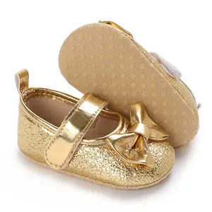 Detailansicht goldener Baby-Prinzessin-Schuhe mit Glitzer, Schleife und rutschfester Sohle.