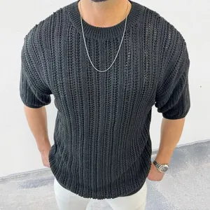 Détail d'un pull en maille ajourée à manches courtes noir pour homme avec un col rond classique