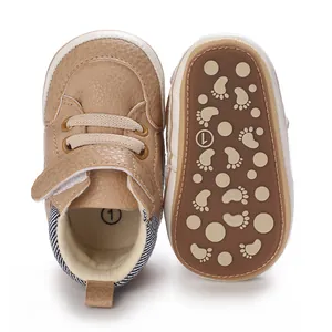 Detailed view of tan soft-sole infant walking shoes with anti-slip footprint pattern sole