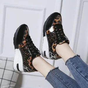 Detalle de zapatillas con cuña para mujer con estampado de leopardo y cordones negros