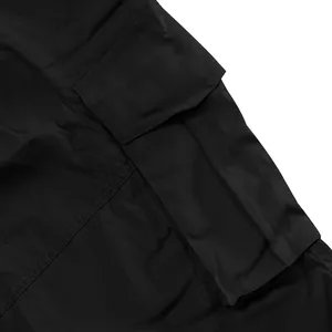 Dettaglio ravvicinato della tasca cargo nera funzionale sui pantaloncini da uomo